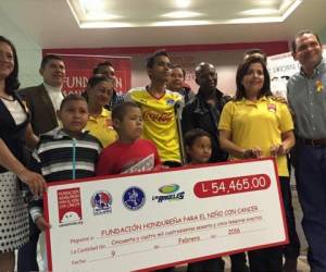 Los representantes de Olimpia y Motagua posan con los menores que asisten a la fundación.