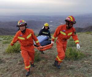 Esta foto tomada el 22 de mayo de 2021 muestra a los rescatistas llevando equipo mientras buscan corredores que competían en una carrera de montaña a campo traviesa de 100 kilómetros cuando el clima extremo golpeó el área, dejando al menos 20 muertos, cerca de la ciudad de Baiyin. Foto: AFP