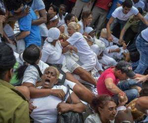 Las mujeres ante la llegada de la policía, se sentaron en el suelo para intentar evitar su traslado, en medio del acoso de los manifestantes a favor del gobierno que les gritaban 'mercenarias' y 'gusanas' (anticastristas)