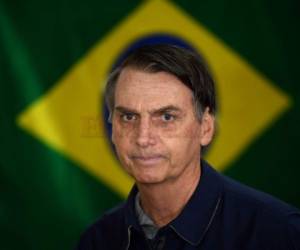 Jair Bolsonaro camina frente a la bandera brasileña. Foto AFP