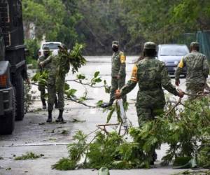 Miembros del Ejército Mexicano retiran árboles caídos de las calles luego del paso del huracán Zeta, en Puerto Morelos, estado de Quintana Roo, México. Foto: Agencia AFP.