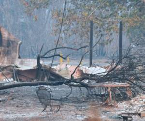 Los bomberos luchan día y noche bajo una espesa nube de humo negro por combatir las llamas en seis frentes. Foto: AFP