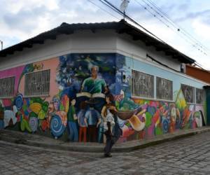 Un hombre camina junto a un mural en un rincón del municipio de Cantarranas, departamento de Francisco Morazán, a 45 km al oeste de Tegucigalpa. Foto: Agencia AFP / ORLANDO SIERRA.
