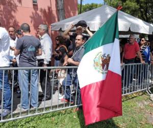 Un admirador sostiene una bandera mexicana mientras espera en fila para entrar al Miami-Dade County Auditorium durante un velorio público del cantante mexicano José José, el domingo 6 de octubre del 2019 en Miami. Fotos: Agencia AP.