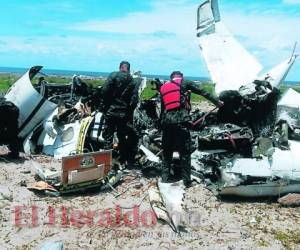Agentes de las Fuerzas Armadas de Honduras inspeccionan los restos de la aeronave siniestrada, y con signos de haber sido incinerada, en una parte totalmente solitaria de las costas del Caribe hondureño.