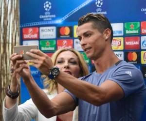 Real Madrid's Portuguese forward Cristiano Ronaldo (R) takes a selfie with a journalist in the mixed zone at Valdebebas Sport City in Madrid on May 30, 2017 at the Media Day event prior to the UEFA Champions League football match final Juventus vs Real Madrid. / AFP PHOTO / PIERRE-PHILIPPE MARCOU