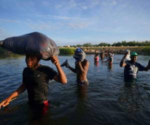 Migrantes, muchos de Haití, cruzan el Río Bravo mientras abandonan Del Río, Texas, para regresar a Ciudad Acuña, México, el miércoles 22 de septiembre de 2021 temprano, algunos para evitar una posible deportación de EEUU otros a conseguir suministros. Foto: AP