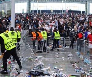 En esta foto del 11 de julio de 2021, empleados de seguridad reacomodan las barricadas derribadas por hinchas ingleses previo a la final del Campeonato Europeo en el estadio Wembley. Foto:AP