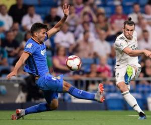 El delantero galo del Real Madrid Gareth Bale patea el balón al defensa uruguayo del Getafe Leandro Cabrera. Foto AFP