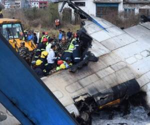 Los socorristas nepaleses se reúnen alrededor de los escombros de un avión que se estrelló cerca del aeropuerto internacional de Katmandú. Al menos 40 personas murieron y 23 resultaron heridas cuando un avión de Bangladesh se estrelló y estalló en llamas. Es el peor desastre aéreo que ha afectado a Nepal en años. Fotos AFP/AP