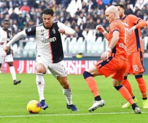 El portugués Cristiano Ronaldo, de la Juventus, se abre paso ante jugadores de Udinese en duelo por la Serie A italiana en el estadio Allianz de Turín. Foto: AP.