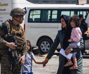 En esta imagen facilitada por el Cuerpo de Infantería de Marina de Estados Unidos, un efectivo estadounidense escolta a evacuados en el aeropuerto internacional Hamid Karzai en Kabul, Afganistán, el viernes 20 de agosto de 2021. (Cabo Davis Harris/Cuerpo de Infantería de Marina de Estados Unidos. Foto: AP