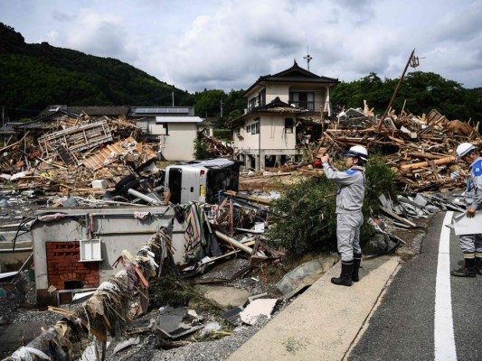 Los trabajadores examinan la devastación después de días de fuertes lluvias e inundaciones en la aldea de Kuma, prefectura de Kumamoto. Foto: Agencia AFP.