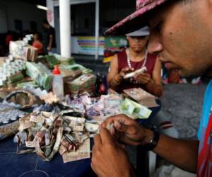 Richard Segovia realiza artesanías de los billetes del Bolivar que en Venezuela prácticamente sirven para nada. Foto: Fernando Vergara | Agencia AP.