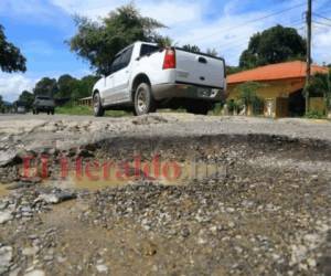 Los enormes baches a lo largo de la carretera arruinan los amortiguadores de los carros.