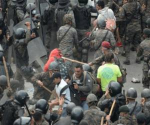 Migrantes hondureños, parte de una caravana que se dirige a Estados Unidos, chocan con las fuerzas de seguridad guatemaltecas en Vado Hondo, Guatemala, el 17 de enero de 2021. La policía guatemalteca lanzó gases lacrimógenos el domingo para tratar de dispersar una caravana de miles de migrantes que se dirigían hacia Estados Unidos . Foto: Johan Ordóñez/ AFP.