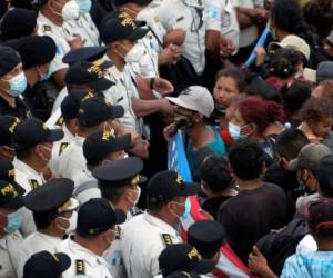 Migrantes hondureños, parte de una caravana que se dirige a Estados Unidos, hablan con policías en Vado Hondo, Guatemala, el 17 de enero de 2021. Foto: AFP