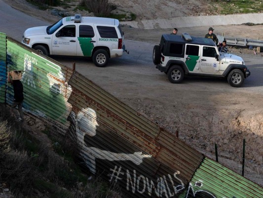 Una mujer y un niño son procesados ​​por agentes de la patrulla fronteriza después de cruzar la valla fronteriza México-EE. UU. Desde Tijuana, México a San Diego, California, desde Tijuana, estado de Baja California, México.