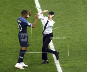 Los manifestantes, miembros del colectivo punk Pussy Riot, invadieron la cancha del Estadio Luzhniki vestidos de agentes de policía durante la segunda mitad del encuentro del domingo entre Francia y Croacia.