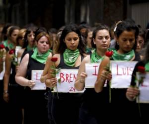 Mujeres marchando desde el Congreso Nacional a la Plaza de Mayo, cada una con una flor y un cartel con el nombre de una mujer asesinada en 2020. Foto AP