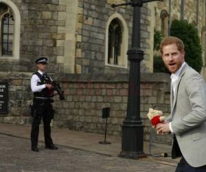 El príncipe Harry cargó un oso teddy rojo que le regalaron cuando saludó a la gente.