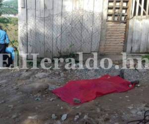 El cadáver de una de las víctimas quedó tendido en una calle de tierra a cercanías de una de las viviendas del sector ocho de la colonia Villanueva, fotos: Estalin Irías/El Heraldo.