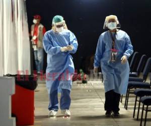 Médicos que se desempeñan en la atención a pacientes sospechosos del virus caminan por el triaje del Centro Cristiano Internacional (CCI) en Tegucigalpa. Foto: Emilio Flores/ EL HERALDO.
