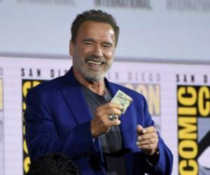 Arnold Schwarzenegger recibe 20 dólares después de ganarle una apuesta al su compañero de reparto Diego Boneta en el panel de 'Terminator: Dark Fate' en el primer día de la Comic-Con International el jueves 18 de julio de 2019 en San Diego.