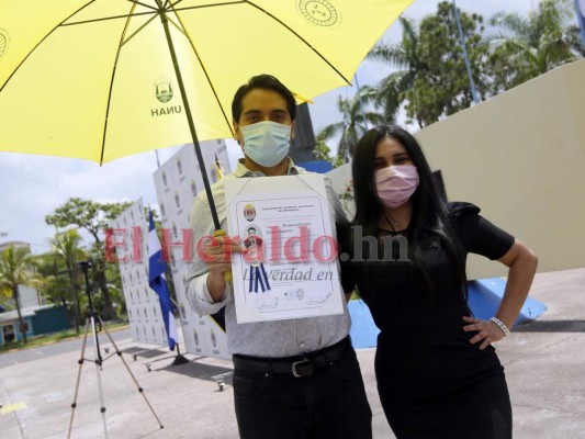 Portando una sombrilla y mascarilla en su rostro, Jermain Enrique Zerón recibió su título acompañado de su novia Liliana Flores. Foto: Marvin Salgado/EL HERALDO.