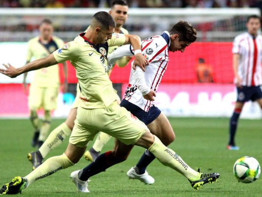 Isaac Brizuela de Guadalajara es desafiado por el argentino Guido Rodríguez de América durante su torneo de fútbol Clausura mexicano en el estadio Akron en Guadalajara, estado de Jalisco, México, el 16 de marzo de 2019. / AFP / Ulises RUIZ.