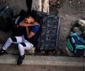 Un solicitante de asilo descansa fuera del puerto de entrada de El Chaparral mientras espera su turno para presentarse ante las autoridades fronterizas de Estados Unidos para solicitar asilo. Foto AFP