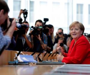 La canciller alemana Angela Merkel, derecha, sonríe al iniciar su conferencia de prensa anual de verano en Berlín, viernes 19 de julio de 2019.