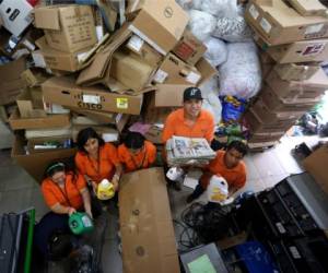 Los jóvenes con discapacidad intelectual, en medio de una montaña de papel y otros materiales listos para reciclar en la asociación Arca de Esperanzas. Foto de Johny Magallanes / El Heraldo.