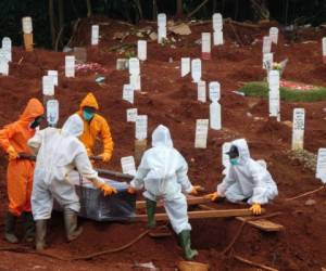 Los trabajadores mueven el ataúd de una víctima del coronavirus Covid-19 a un lugar de enterramiento en un cementerio en Yakarta, Indonesia. Foto: AFP.