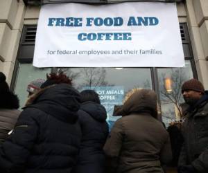 Un grupo de personas que trabajan para el gobierno estadounidense hacen fila para obtener algo de comida. (Foto: AFP)