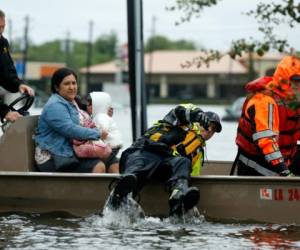 A member of the Louisiana Department of Wildlife and Fisheries maneuvers while rescuing stranded residents during flooding from Tropical Storm Harvey in Houston, Monday, Aug. 28, 2017. (AP Photo/Gerald Herbert)