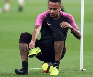 El delantero brasileño de Paris Saint-Germain Neymar ajustando su zapato durante el campamento de entrenamiento de invierno del equipo en el Estadio Internacional Khalifa en Doha. El entrenador del Paris Saint-Germain.