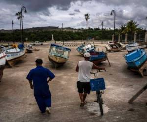 Pescadores inspeccionan sus botes después de retirarlos del agua para evitar daños con el paso de la tomenta tropical Elsa, en La Haba, Cuba, 5 de julio de 2021. Foto: AP