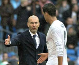Zinedine Zidane junto a Raphael Varane en el Real Madrid. (AFP)