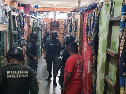 Miembros de la Policía Militar del Orden Público revisan los dormitorios de los privados de libertad.