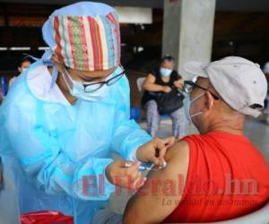 Una persona es vacunada contra el covid-19 en el punto peatonal del Polideportivo de la UNAH. Foto: El Heraldo