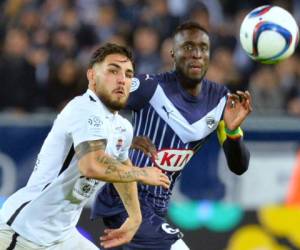 Andy Delort del Bordeaux pelea un balón con el senegalés Lamine Sane del Caen.