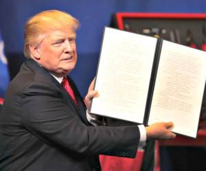 El presidente Donald Trump muestra la orden ejecutiva que firmó en Kenosha, Wisconsin, para la revisión de las visas de trabajo. Foto: Scott Olson/Getty Images/AFP/EL HERADO.