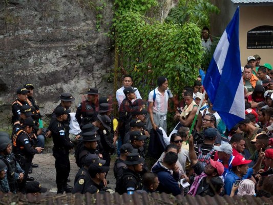 Agentes de la policía guatemalteca bloquean el cruce de la frontera donde cientos de migrantes hondureños han llegado a Agua Caliente, Guatemala, el lunes 15 de octubre de 2018. La caravana de hondureños avanza hacia la frontera del país con Guatemala. Nueva vida en los Estados Unidos. (Foto AP / Moises Castillo).
