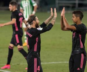 El defensor español del Real Madrid Sergio Ramos celebra con el defensor francés Raphael Varane después de anotar durante el partido de fútbol de la liga española Real Betis contra Real Madrid CF en el estadio Benito Villamarín de Sevilla el 26 de septiembre de 2020. Foto: Agencia AFP.