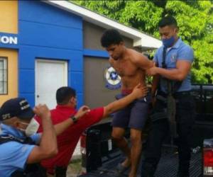 Momento en que uno de los capturados es trasladado por la policía.