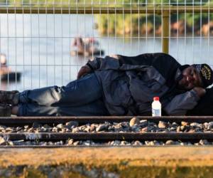 Un hondureño descansa en el puente que Internacional que una a Guatemala con México. Foto: AFP