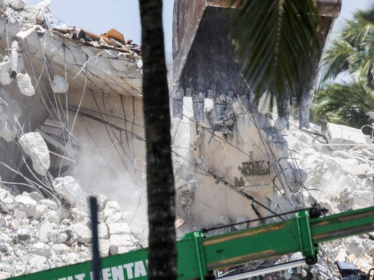 Una excavadora transporta escombros en el sitio del edificio de condominios Champlain Towers South colapsado de 12 pisos el 8 de julio de 2021 en Surfside, Florida. Foto: Agencia AFP.