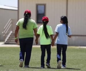 Tres inmigrantes que desean recibir asilo en Estados Unidos caminan tomadas de la mano al salir de una cafetería en el Centro Residencial para Familias del Sur de Texas. Foto: AP.