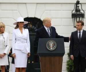 Brigitte y Melania en el primer plano, seguidas de sus esposos Trump y Macron. Foto AFP